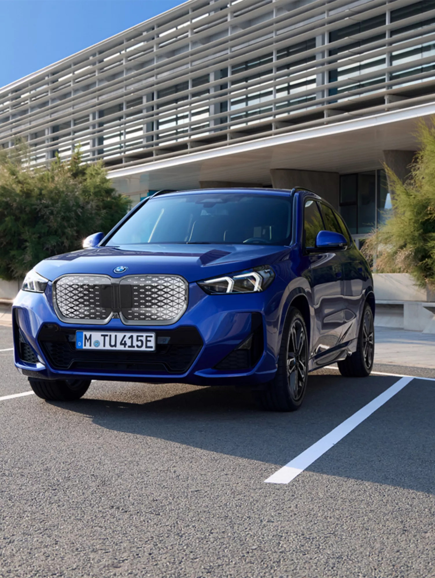 Two BMW electric cars painted red and blue on a surreal road