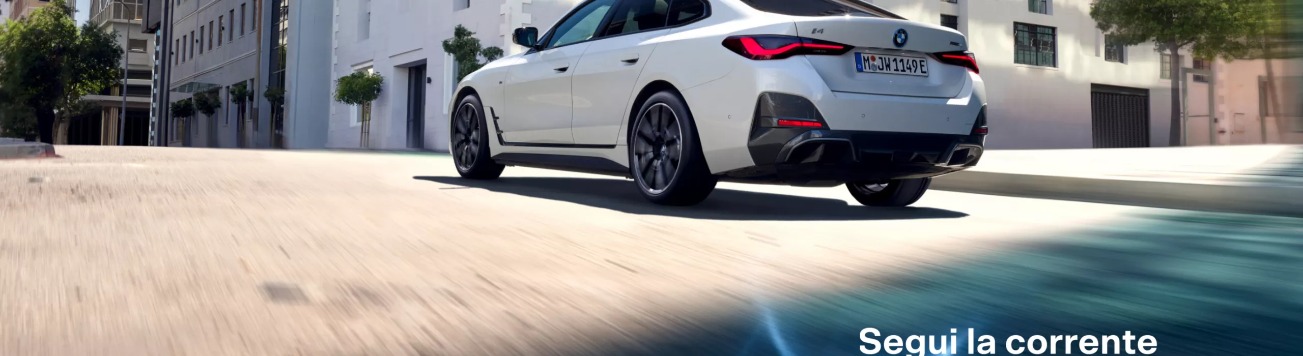 BMW percorre una strada in città. Inquadratura dal basso da dietro