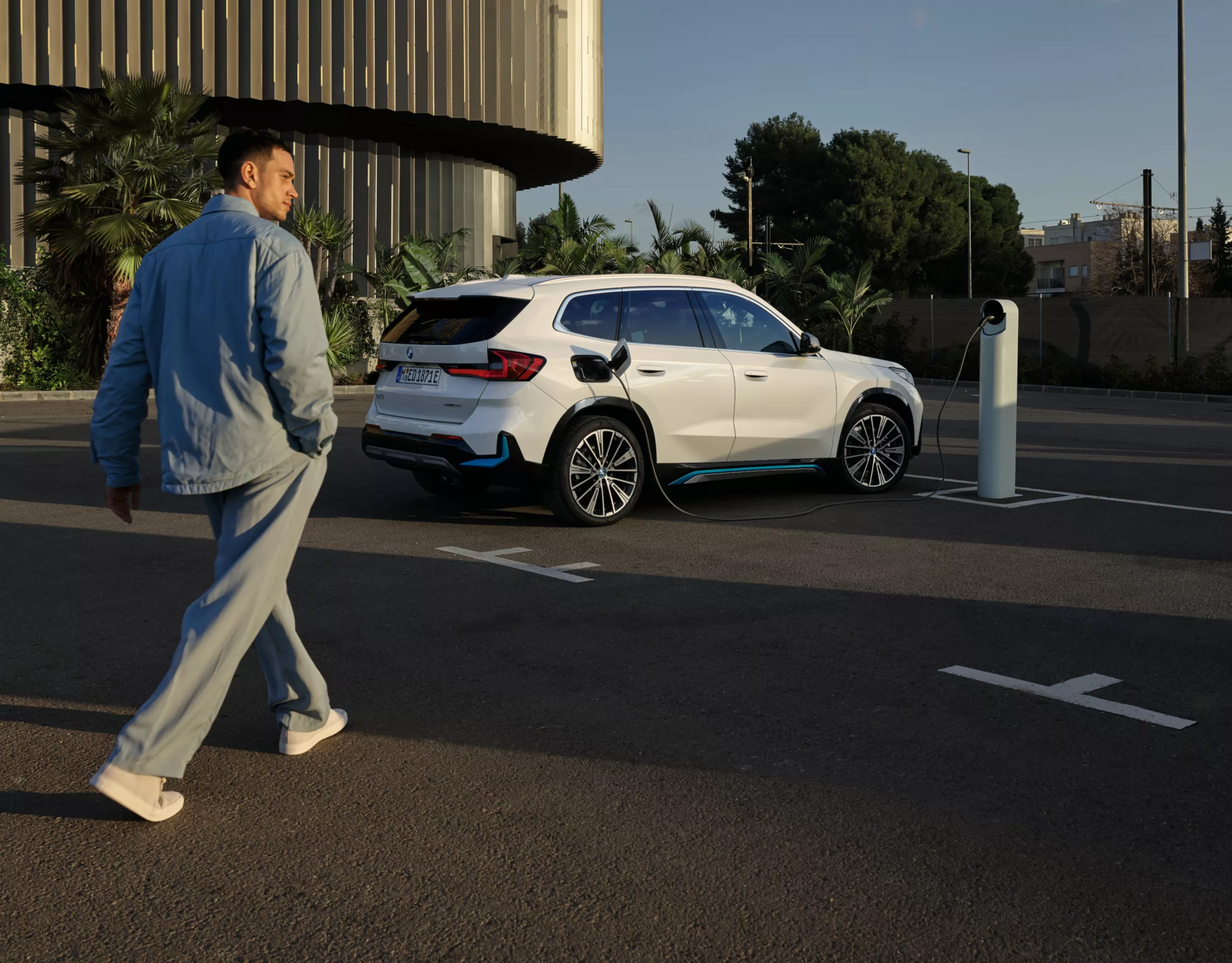  Un uomo cammina dietro a una BMW iX1